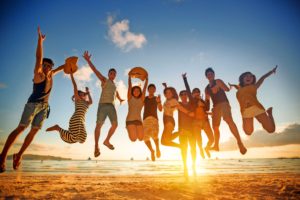 Group of young people jumping on beach